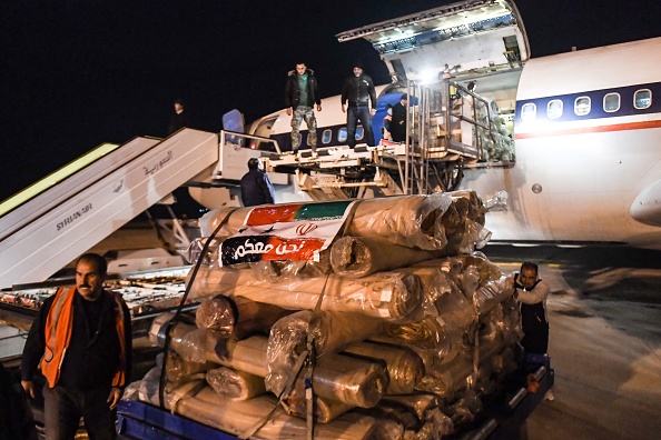 Des travailleurs déchargent l'aide envoyée par l'Iran par avion, à l'aéroport de la ville d'Alep, tôt le 8 février 2023, à la suite du séisme. (Photo : -/AFP via Getty Images)