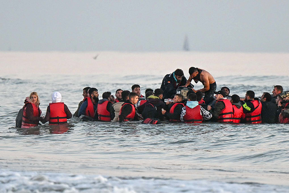 Une quarantaine de migrants, d'origines diverses, montent à bord d'un bateau pneumatique avant de tenter de traverser illégalement la Manche vers la Grande-Bretagne. 
(Photo DENIS CHARLET/AFP via Getty Images)