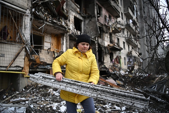 Une femme dégage les débris d'un immeuble résidentiel endommagé dans la rue Koshytsa, dans la banlieue de la capitale ukrainienne Kiev. (DANIEL LEAL/AFP via Getty Images)