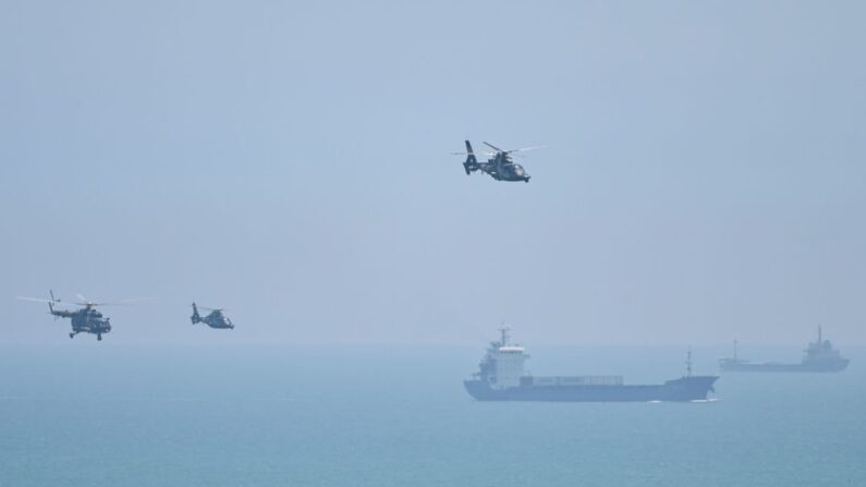 Hélicoptères de l'APL (armée chinoise) survolant l'île de Pingtan, un des points de la Chine continentale les plus proches de Taïwan, dans la province de Fujian, le 4 août 2022, à l'approche d'exercices militaires massifs au large de Taïwan, suite à la visite de Nancy Pelosi. (HECTOR RETAMAL/AFP via Getty Images)