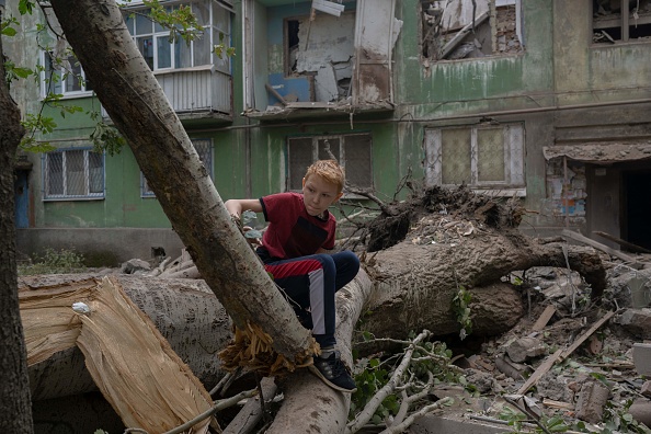 Un adolescent observe les dégâts après une attaque des forces russes à Kostiantynivka, dans l'est de l'Ukraine. (BULENT KILIC/AFP via Getty Images)