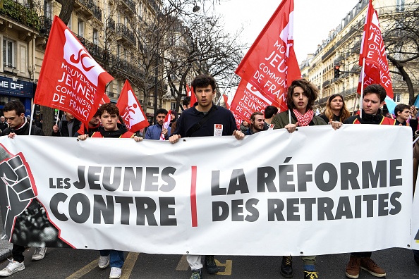 Des jeunes marchent derrière une banderole lors d'une manifestation à Paris contre la réforme du système de retraite. (BERTRAND GUAY/AFP via Getty Images)
