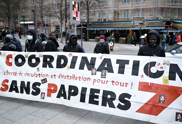 Des personnes participent à une manifestation contre la proposition de loi Darmanin sur l'immigration et les centres de rétention administrative à Paris en février 2023. (STÉPHANE DE SAKUTIN/AFP via Getty Images)