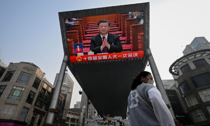 Un écran géant installé dans une rue de Pékin montre le dirigeant chinois Xi Jinping lors de la session d'ouverture de l'Assemblée nationale populaire au Grand palais du Peuple, à Pékin, le 5 mars 2023. (Jade Gao/AFP via Getty Images)