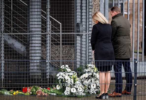 La ministre allemande de l'Intérieur Nancy Faeser et le sénateur de l'Intérieur de Hambourg Andy Grote s'inclinent devant des fleurs déposées où plusieurs personnes ont été tuées dans une église lors d'une fusillade à Hambourg, le 10 mars 2023. (AXEL HEIMKEN/AFP via Getty Images)