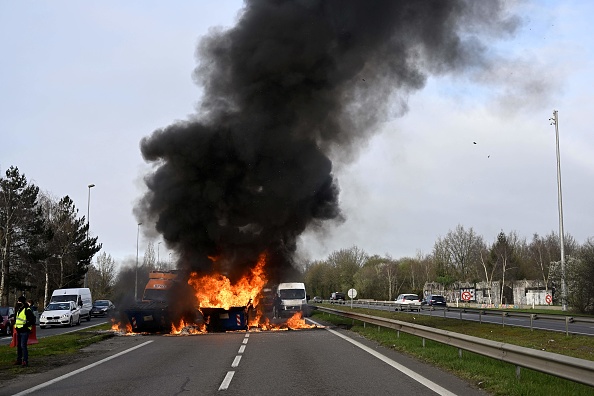 Des bennes brûlent et bloquent une partie de l'autoroute lors d'une manifestation à Rennes pour s'opposer à la réforme des retraites. (DAMIEN MEYER/AFP via Getty Images)