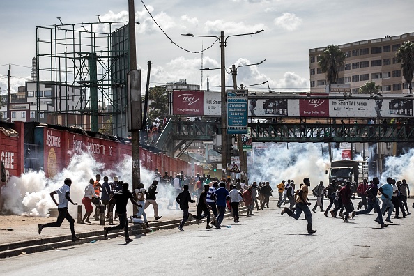 Des personnes courent se mettre à l'abri des gaz lacrymogènes tirés par la police kényane à Nairobi, au Kenya, le 20 mars 2023. (LUIS TATO/AFP via Getty Images)