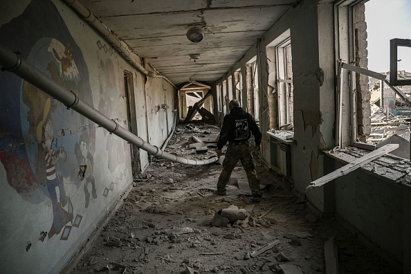 Un résident local marche à l'intérieur d'une école détruite à Bakhmut, le 22 mars 2023. (ARIS MESSINIS/AFP via Getty Images)