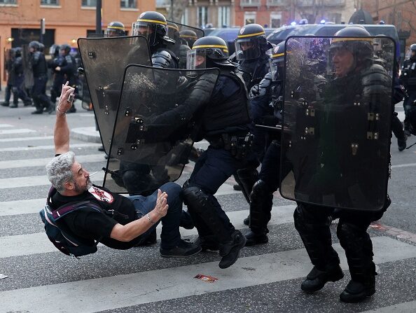 Des policiers des Compagnies républicaines de sécurité (CRS) en tenue anti-émeute affrontent un manifestant, à Toulouse, le 23 mars 2023. (CHARLY TRIBALLEAU/AFP via Getty Images)