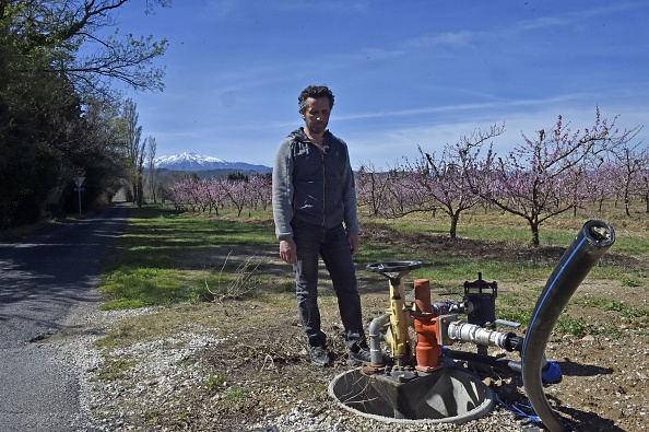 David Massot, arboriculteur, devant les vannes d'eau qui irriguent ses vergers de nectarines au pied du mont Canigou menacé par la sécheresse, à Corbère-Les-Cabanes, le 20 mars 2023. (RAYMOND ROIG/AFP via Getty Images)
