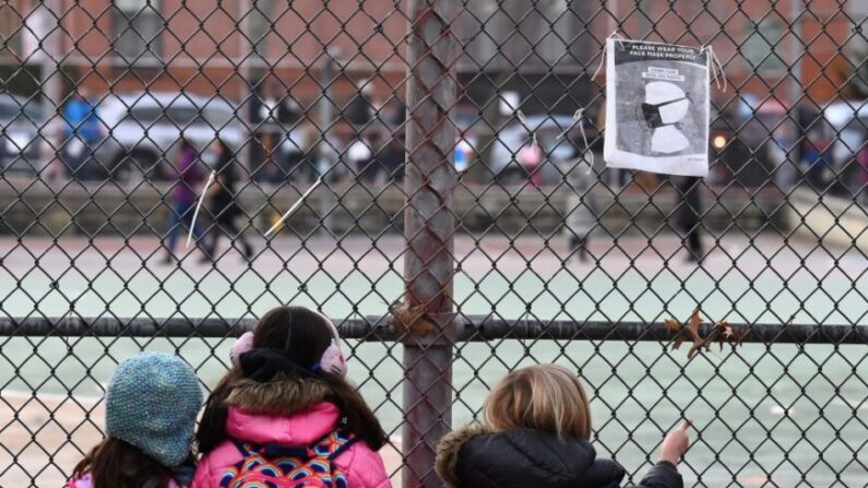 
Des enfants regardent la cour de leur école en attendant d'aller en classe le premier jour de la réouverture des classes dans l'arrondissement de Brooklyn à New York, le 7 décembre 2020. (Angela Weiss/AFP via Getty Images)
