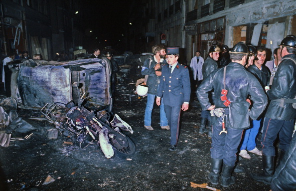 Des pompiers près des débris d'une voiture et d'une moto après un attentat à la bombe dans une synagogue de Paris, rue Copernic, qui a fait quatre morts, le 03 octobre 1980. (-/AFP via Getty Images)
