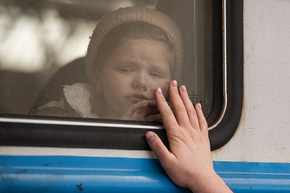 Une jeune fille pleure tandis qu'un homme dit au revoir à sa fille à la gare, le 22 mars 2022 à Lviv, en Ukraine. (Alexey Furman/Getty Images)