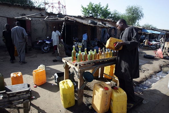 Un Nigérian vendant de l'essence au marché noir attend un client sur le trottoir d'une rue de Maradi, ville du sud du Niger. Illustration (MUSTAFA OZER/AFP via Getty Images)