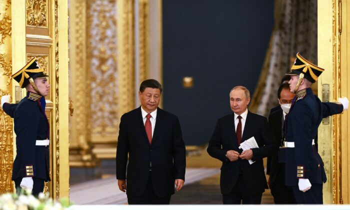 Le président russe Vladimir Poutine et le dirigeant chinois Xi Jinping entrent dans une salle lors d'une réunion au Kremlin à Moscou, le 21 mars 2023. (Alexey Maishev/ Sputnik/AFP via Getty Images)