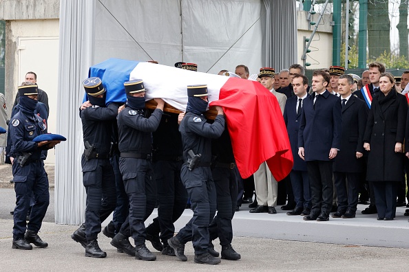 Des gendarmes portent le cercueil d’Arnaud Blanc, tué lors d'une opération de lutte contre l'orpaillage clandestin en Guyane, à Versailles, le 31 mars 2023, devant Emmanuel Macron.(LUDOVIC MARIN/POOL/AFP via Getty Images)