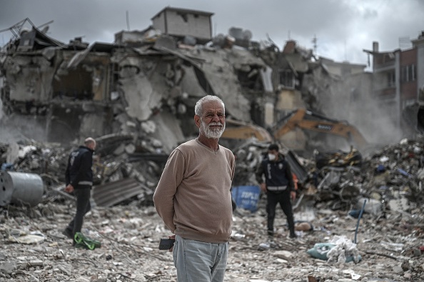 Ali Cimen, ouvrier du bâtiment, devant des bâtiments effondrés dont les décombres sont en train d'être enlevés à Antakya, le 5 avril 2023. (OZAN KOSE/AFP via Getty Images)