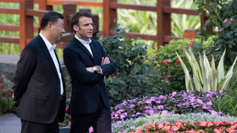 Le leader chinois Xi Jinping et le président français Emmanuel Macron parlent alors qu'ils visitent le jardin de la résidence du gouverneur du Guangdong, le 7 avril 2023. (JACQUES WITT/POOL/AFP via Getty Images)