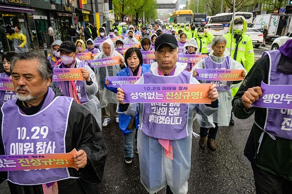 Un rassemblement près de l'allée où la catastrophe a eu lieu dans le quartier populaire d'Itaewon, à Séoul. (ANTHONY WALLACE/AFP via Getty Images)