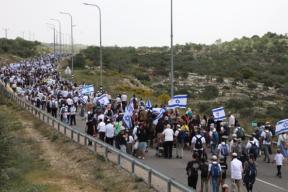 Des colons israéliens marchent vers l'avant-poste d'Eviatar, près du village palestinien de Beita, au sud de Naplouse, en Cisjordanie occupée, le 10 avril 2023. (GIL COHEN-MAGEN/AFP via Getty Images)
