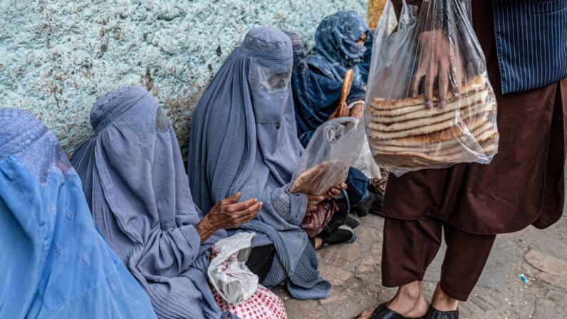 Des femmes afghanes attendent la distribution de pain gratuit d'une association caritative pendant le mois de jeûne du Ramadan à Kaboul, le 13 avril 2023. (WAKIL KOHSAR/AFP via Getty Images)
