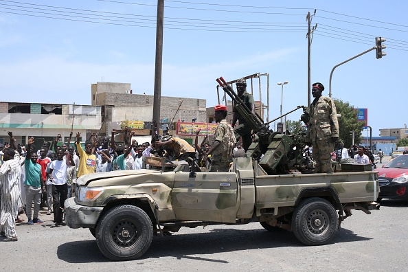 Des Soudanais saluent les soldats de l'armée, fidèles au chef de l'armée Abdel Fattah al-Burhan, dans la ville de Port-Soudan, le 16 avril 2023. (AFP via Getty Images)