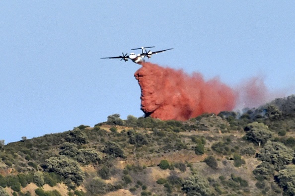 Un avion largue du produit ignifuge sur un feu de forêt sur une colline près du village de Banyuls-sur-Mer. (RAYMOND ROIG/AFP via Getty Images)