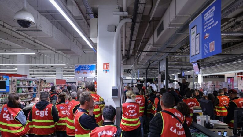 Des syndicalistes de la CGT occupent un supermarché Auchan pour protester contre la nouvelle réforme des retraites, à Paris, le 19 avril 2023. (Photo THOMAS SAMSON/AFP via Getty Images)