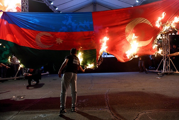 Des manifestants brûlent les drapeaux turcs et azerbaïdjanais, le 23 avril 2023, lors de la commémoration du génocide arménien, à Erevan. (KAREN MINASYAN/AFP via Getty Images)