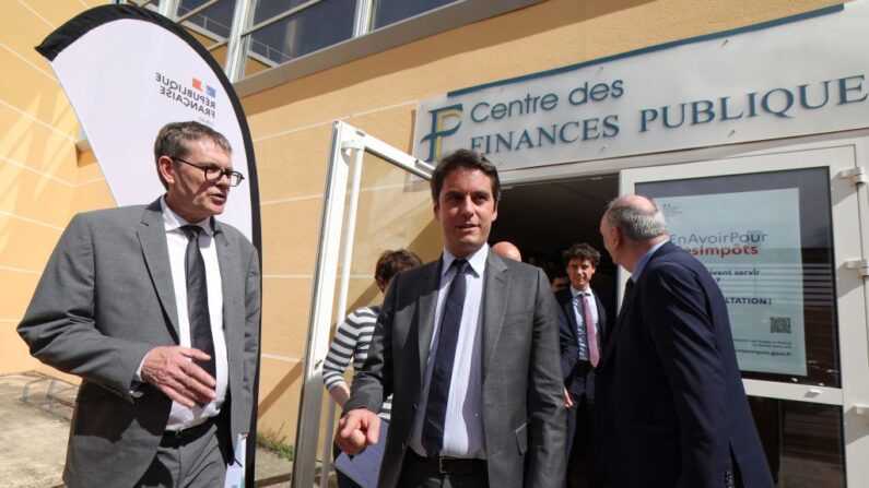 Le ministre français des Comptes publics Gabriel Attal (au c.) quitte le Centre des finances publiques après une réunion avec les employés. (Photo  PASCAL GUYOT/AFP via Getty Images)
