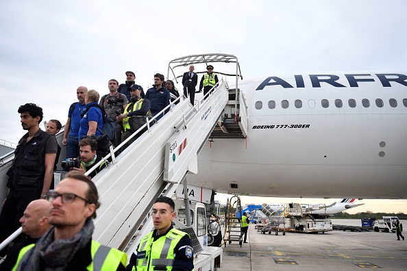 Des personnes débarquent d'un avion en provenance de Djibouti après avoir été évacuées du Soudan, à l'aéroport Roissy-Charles-de-Gaulle. (JULIEN DE ROSA/AFP via Getty Images)