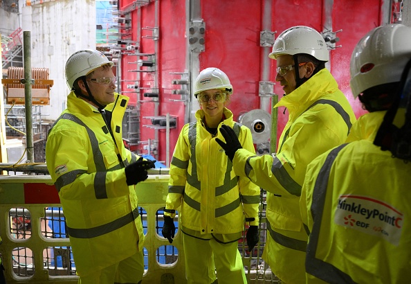 La ministre de la Transition énergétique Agnès Pannier-Runacher (au milieu) et Luc Remont, PDG d'EDF (à d.) lors d'une visite de la centrale nucléaire de Hinkley Point C près de Bridgwater, dans le sud-ouest de l'Angleterre, le 27 avril 2023. (DANIEL LEAL/AFP via Getty Images)