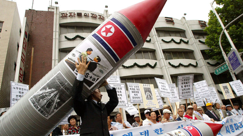 Des manifestants sud-coréens portent un faux missile nucléaire lors d'un rassemblement contre la Corée du Nord visant à mettre fin au développement présumé d'armes nucléaires par la Corée du Nord devant l'hôtel Shilla où les deux Corées tiennent des pourparlers au niveau du cabinet, le 10 juillet 2003 à Séoul, en Corée du Sud.  (Photo by Chung Sung-Jun/Getty Images)