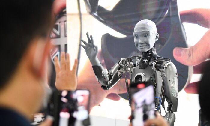 Les participants prennent des photos et interagissent avec le robot humanoïde Engineered Arts Ameca doté d'une intelligence artificielle lors d'une démonstration au Consumer Electronics Show (CES) à Las Vegas, Nevada, le 5 janvier 2022. (Patrick T. Fallon/AFP via Getty Images)
