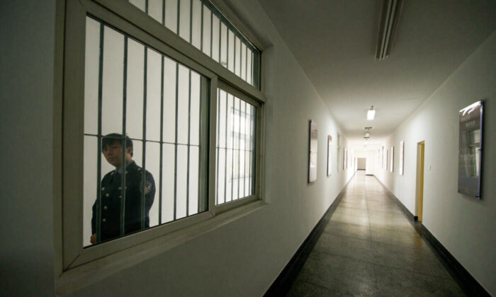 Un gardien regarde à travers la fenêtre d'un couloir à l'intérieur du centre de détention n° 1 lors d'une visite guidée par le gouvernement à Pékin le 25 octobre 2012. (Ed Jones/AFP via Getty Images)

