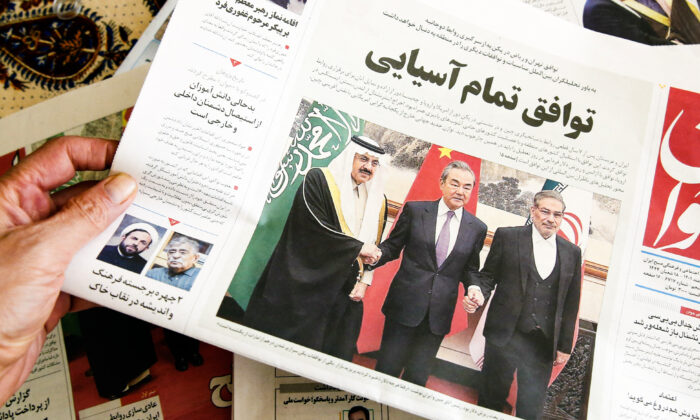 Un homme tient un journal local relatant l'accord conclu entre l'Iran et l'Arabie saoudite pour rétablir les liens, à Téhéran, capitale de l'Iran, le 11 mars 2023. (Atta Kenare/AFP via Getty Images)