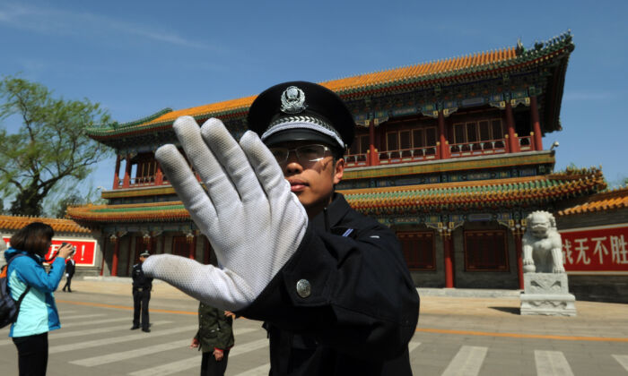 Un policier empêche la prise de photos à l'extérieur de Zhongnanhai, le siège central du Parti communiste chinois, à Pékin, le 11 avril 2012. (Mark Ralston/AFP/Getty Images)