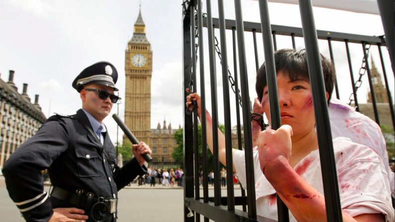 Reconstitution de torture par des pratiquants de Falun Gong, lors d'une manifestation devant les Chambres du Parlement à Londres, le 20 juillet 2009. (Shaun Curry/AFP via Getty Images)


