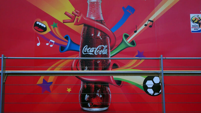 Sur les murs, la marque de boissons gazeuses Coca-Cola promet d’ « ouvrir du bonheur ». Warrenski / Fickr, CC BY-SA