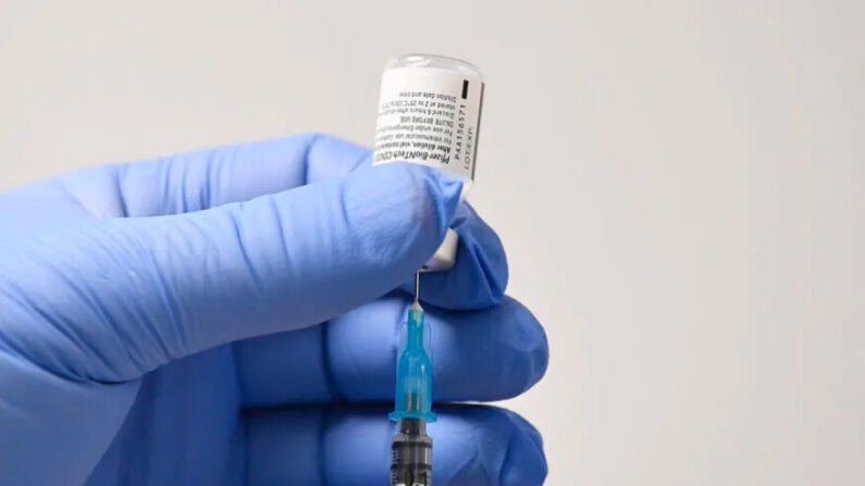 Un membre du personnel utilise une aiguille et une fiole de vaccin Pfizer-BioNTech Covid-19 pour préparer une dose dans un centre de santé de vaccination à Cardiff, au sud du Pays de Galles' le 8 décembre 2020. (Photo par JUSTIN TALLIS/AFP via Getty Images)