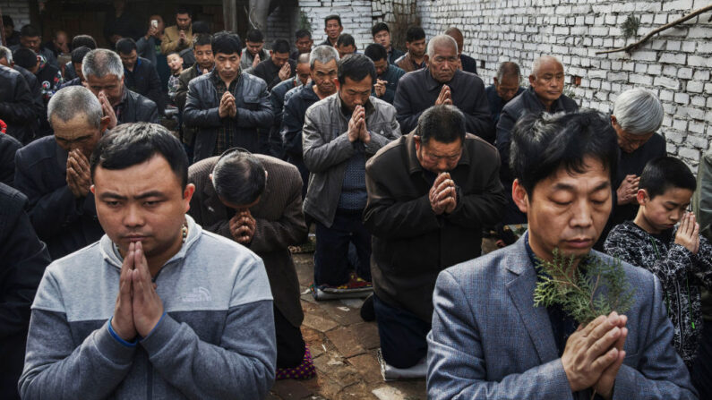 Des fidèles catholiques chinois s'agenouillent et prient pendant la messe du dimanche des Rameaux lors de la Semaine sainte de Pâques dans une église souterraine, le 9 avril 2017. (Kevin Frayer/Getty Images)