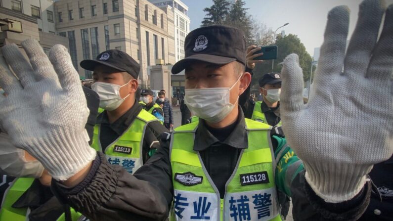 Des policiers tentent d'empêcher des journalistes de prendre des images devant le tribunal populaire du nouveau district de Shanghai Pudong, où la journaliste indépendante chinoise Zhang Zhan doit être jugée, à Shanghai, le 28 décembre 2020. (Leo Ramirez/AFP via Getty Images)