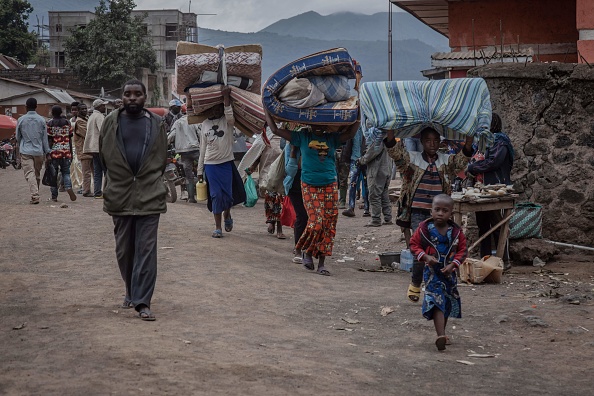 Des personnes tentent de traverser la frontière entre la République démocratique du Congo (RDC) et l'Ouganda en avril 2022. (GUERCHOM NDEBO/AFP via Getty Images)
