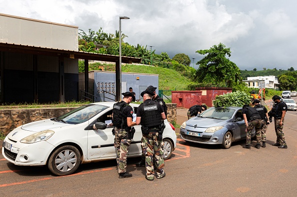 Des gendarmes contrôlent des voitures dans la ville de Koungou. (MORGAN FACHE/AFP via Getty Images)