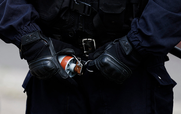 Un policier s'apprête à utiliser une grenade de désencerclement lors d'affrontements avec des manifestants à Lille le 1er mai. Les violences de la part de certains policiers font l'objet d'enquêtes de l'IGPN dont le rôle est très critiqué par la société civile. (SAMEER AL-DOUMY/AFP via Getty Images)