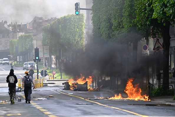 Des poubelles en feu en marge d'une manifestation du 1er mai, à Rennes. (DAMIEN MEYER/AFP via Getty Images)