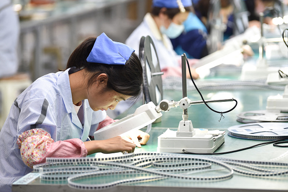 Un ouvrier produisant des composants électroniques dans une usine en Chine. Illustration. (STR/AFP via Getty Images)
