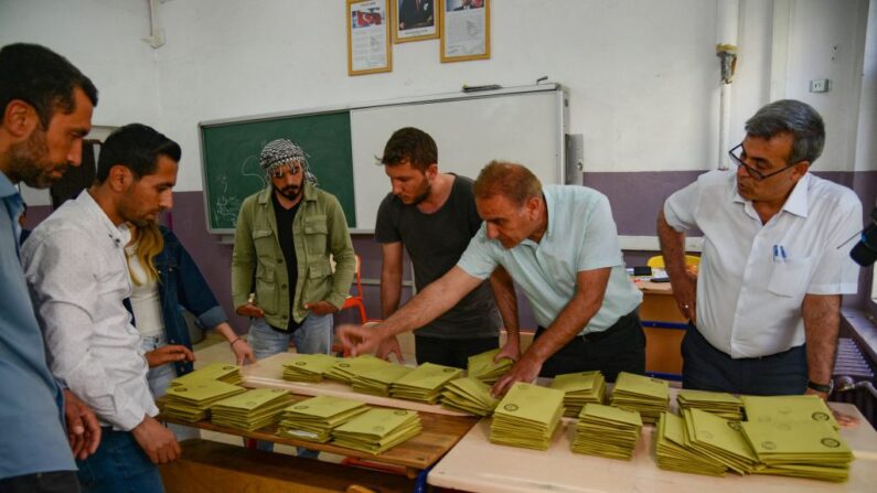 Des agents électoraux comptent les bulletins de vote dans un bureau de vote après la fermeture des bureaux de vote pour les élections présidentielles et parlementaires en Turquie à Diyarbakir, le 14 mai 2023. (Photo ILYAS AKENGIN/AFP via Getty Images)