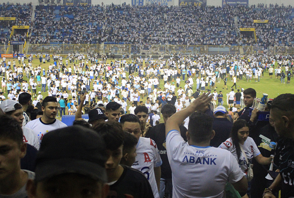 Des fans envahissent le terrain après une bousculade lors d'un match de football entre Alianza et FAS au stade Cuscatlan à San Salvador le 20 mai 2023. (GABRIEL AQUINO/AFP via Getty Images)