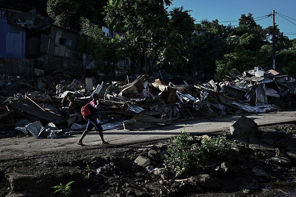 Un homme passe devant des bâtiments démolis dans le bidonville du quartier "Talus 2" à Koungou, à Mayotte, le 23 mai 2023. (PHILIPPE LOPEZ/AFP via Getty Images)